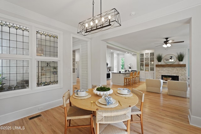 12 Sheffield Ct, Beaufort, SC 29907 - dining room featuring light wood-style flooring, a ceiling fan, baseboards, and a fireplace