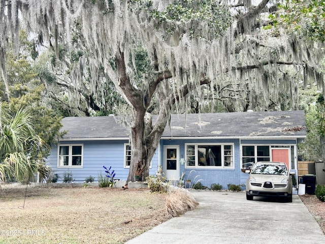 ranch-style house featuring a garage and a front lawn