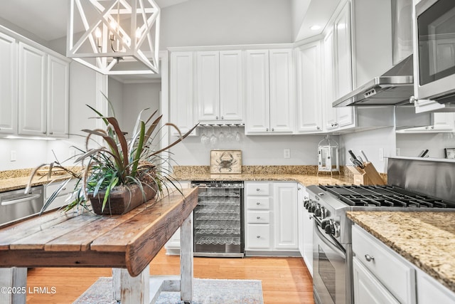 kitchen featuring appliances with stainless steel finishes, beverage cooler, and white cabinetry