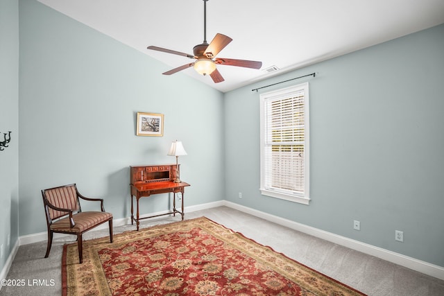 sitting room featuring carpet, baseboards, and a ceiling fan