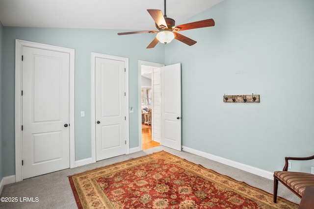 bedroom with light carpet, baseboards, vaulted ceiling, and a ceiling fan