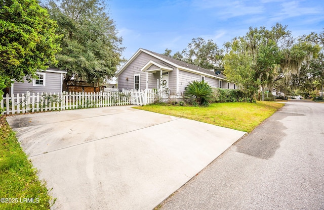 view of front of house with driveway, fence, and a front lawn