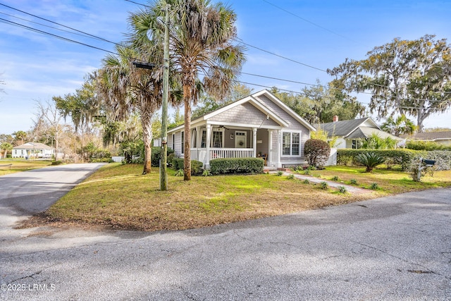 view of front facade featuring covered porch and a front yard