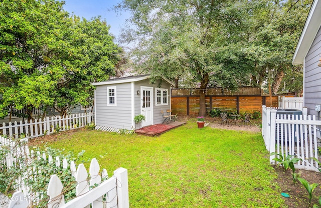 view of yard with a fenced backyard, an outdoor structure, central AC, and a shed