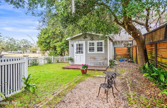 view of outdoor structure with a fenced backyard and an outbuilding