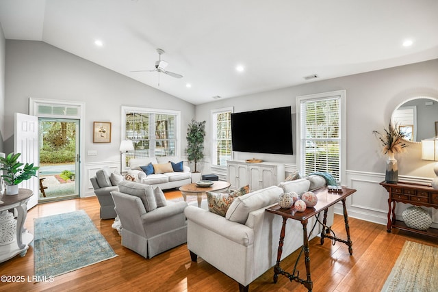 living room with recessed lighting, a ceiling fan, vaulted ceiling, wainscoting, and wood-type flooring