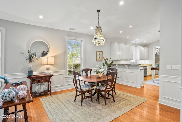 dining space featuring a wainscoted wall, light wood-style flooring, and recessed lighting