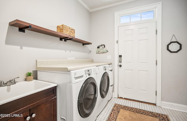 washroom with light tile patterned floors, ornamental molding, a sink, and washing machine and dryer