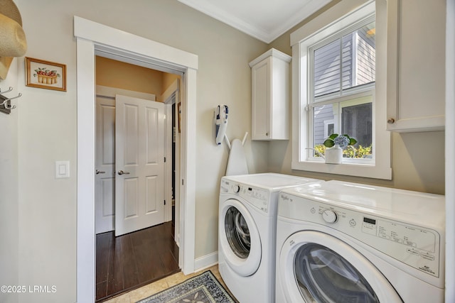 laundry area featuring cabinets, ornamental molding, separate washer and dryer, and light hardwood / wood-style floors