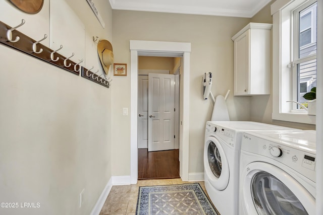 clothes washing area featuring cabinets, ornamental molding, washing machine and dryer, and light tile patterned floors