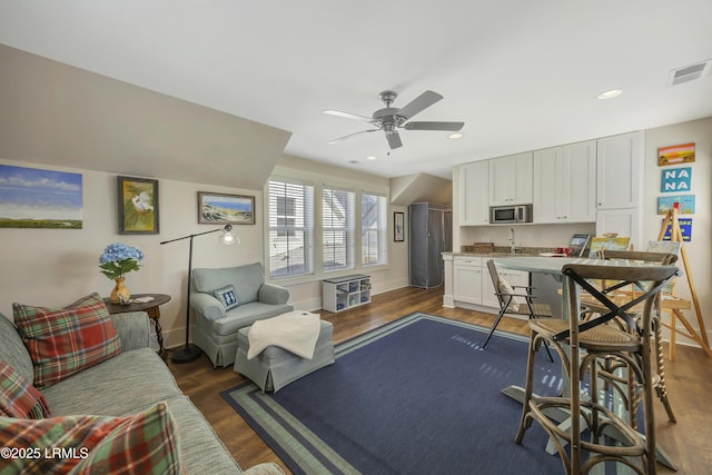 living room with dark hardwood / wood-style floors, sink, and ceiling fan