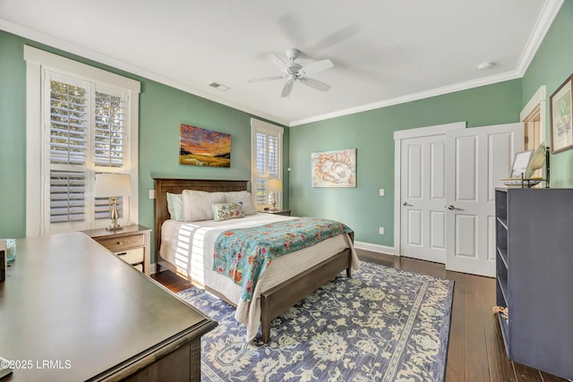 bedroom with dark hardwood / wood-style flooring, ornamental molding, and ceiling fan