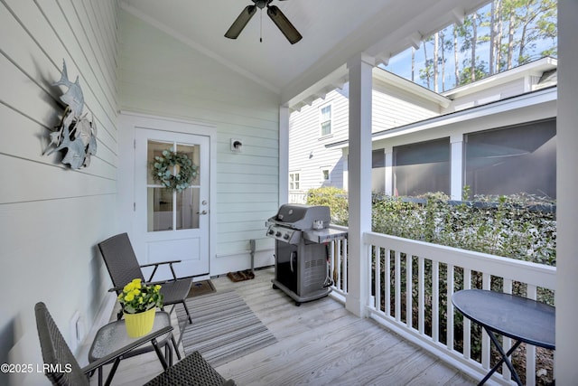 wooden deck with ceiling fan and area for grilling