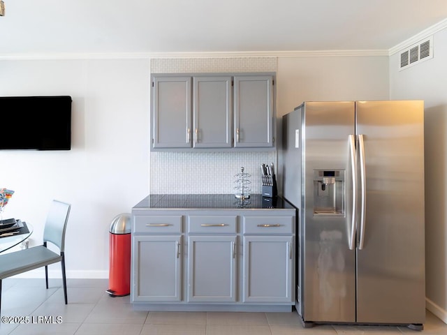 kitchen featuring crown molding, gray cabinets, stainless steel fridge with ice dispenser, and backsplash