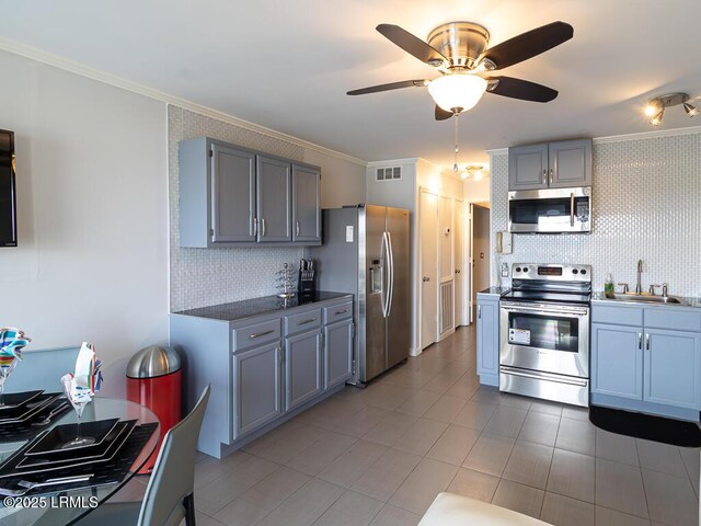 kitchen featuring sink, crown molding, backsplash, and appliances with stainless steel finishes