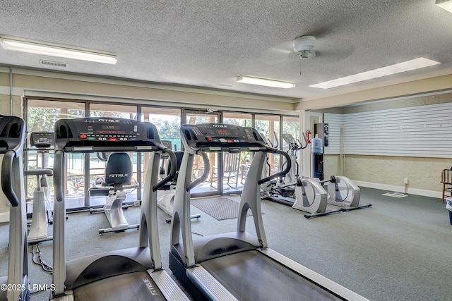 workout area featuring ceiling fan and a textured ceiling