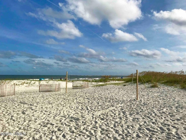 view of home's community with a water view and a beach view