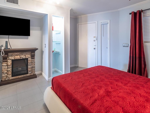 bedroom featuring ornamental molding, a stone fireplace, and light tile patterned floors