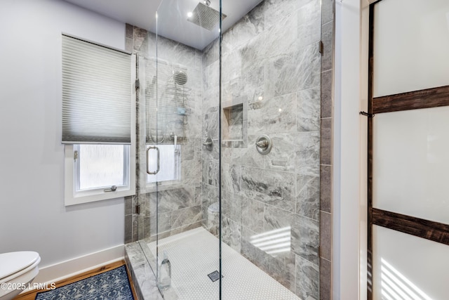 bathroom with a shower with door and toilet