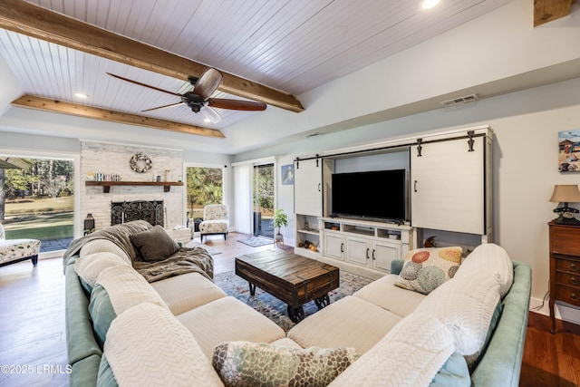 living room with wood ceiling, wood-type flooring, a fireplace, and beamed ceiling