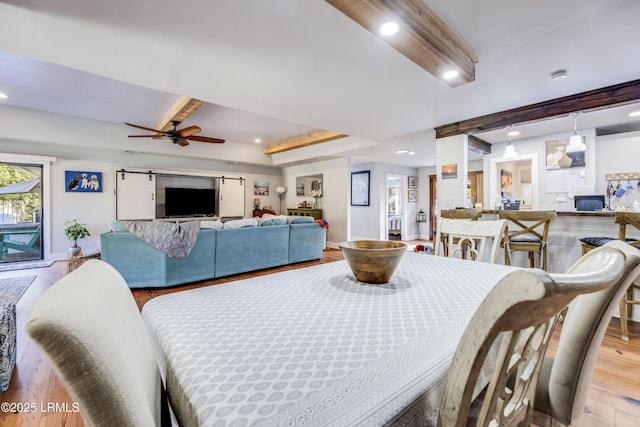 dining space with ceiling fan, light hardwood / wood-style flooring, and beamed ceiling