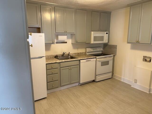 kitchen featuring gray cabinetry, sink, white appliances, and a textured ceiling