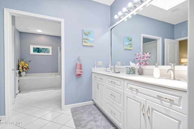 bathroom featuring tile patterned floors, a tub to relax in, a skylight, and vanity