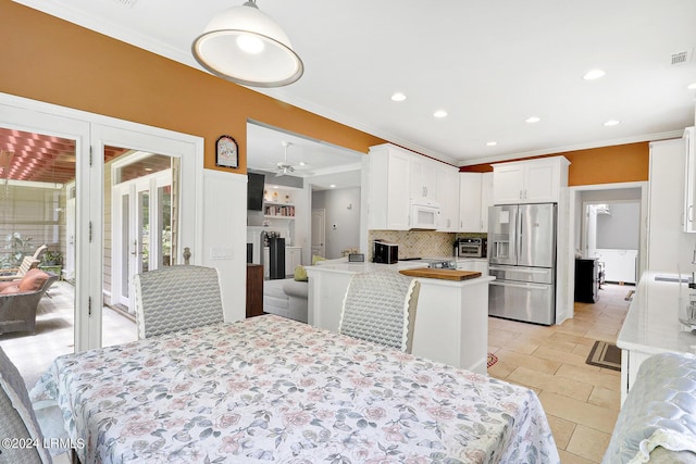 dining area with ceiling fan, ornamental molding, and light tile patterned floors