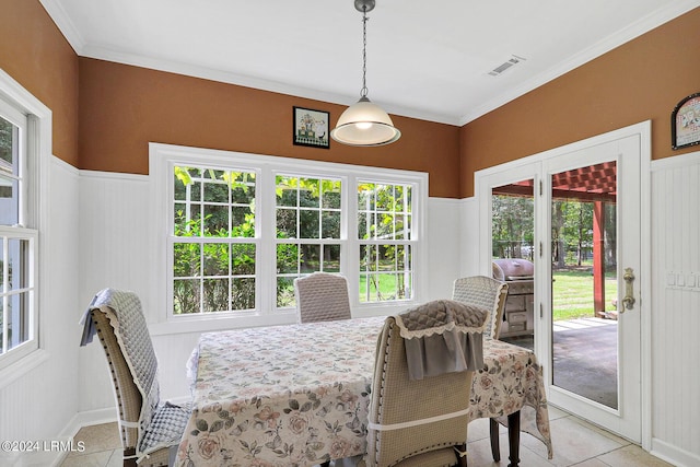 dining room featuring crown molding and light tile patterned flooring