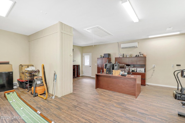 home office featuring hardwood / wood-style floors and an AC wall unit