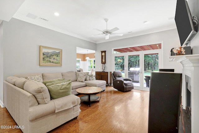 living room featuring hardwood / wood-style flooring, crown molding, ceiling fan, and french doors