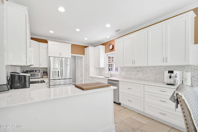 kitchen featuring sink, white cabinetry, crown molding, light tile patterned floors, and stainless steel appliances