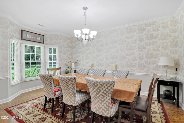 dining room featuring crown molding, parquet flooring, and a chandelier