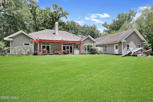 back of property with a yard and a pergola