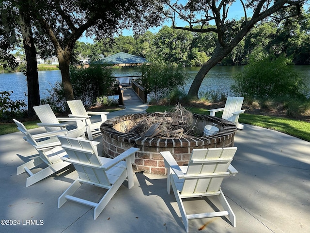 view of patio / terrace featuring an outdoor fire pit and a water view