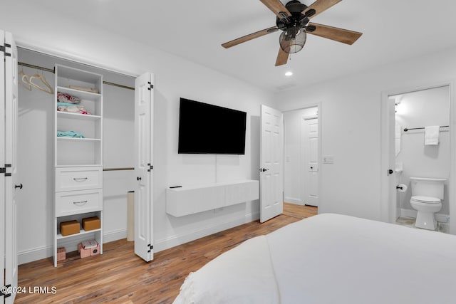 bedroom with hardwood / wood-style flooring, ensuite bathroom, and ceiling fan