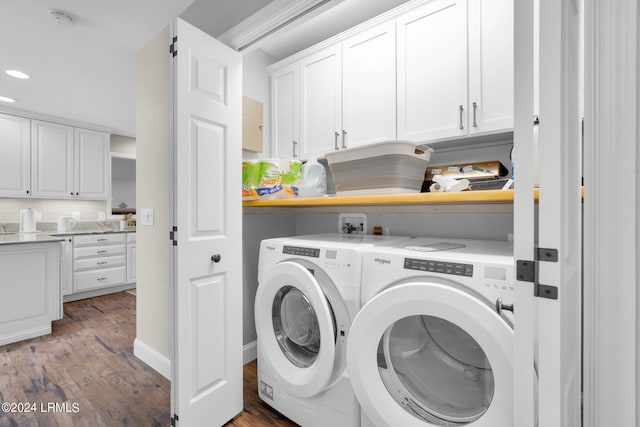 washroom featuring washer and clothes dryer, light hardwood / wood-style floors, and cabinets