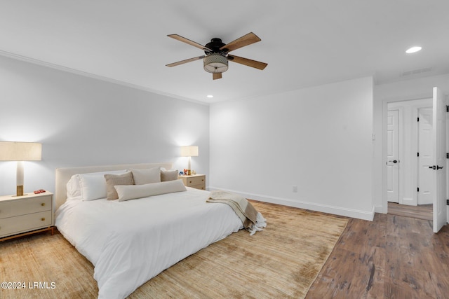 bedroom featuring hardwood / wood-style flooring, ceiling fan, and crown molding