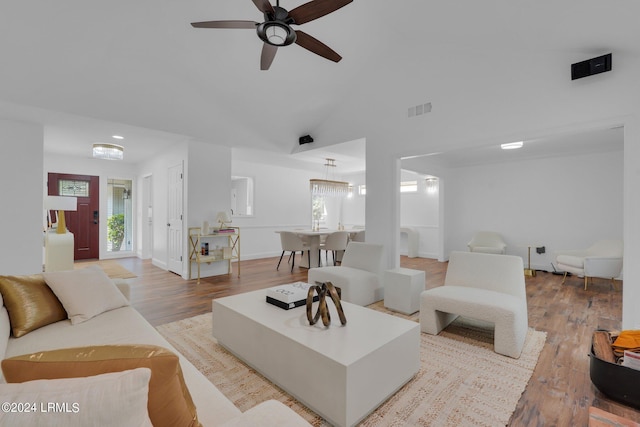 living room featuring light hardwood / wood-style flooring, ceiling fan, and vaulted ceiling