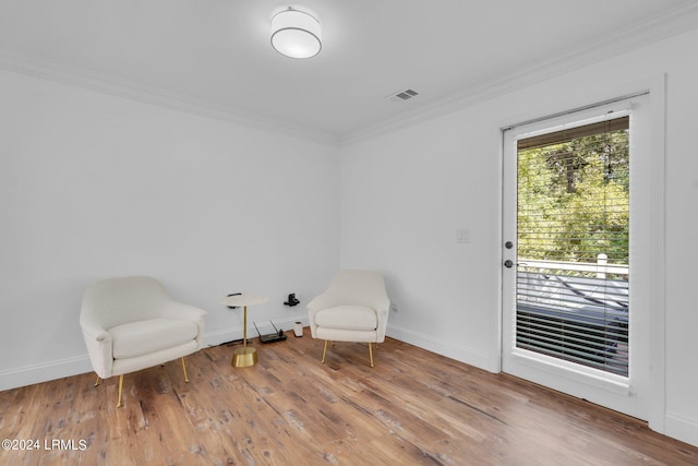 sitting room featuring ornamental molding and hardwood / wood-style floors