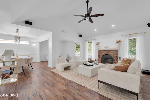 living room with light hardwood / wood-style flooring, a fireplace, a wealth of natural light, and high vaulted ceiling