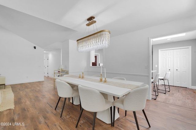 dining space with hardwood / wood-style floors and a notable chandelier