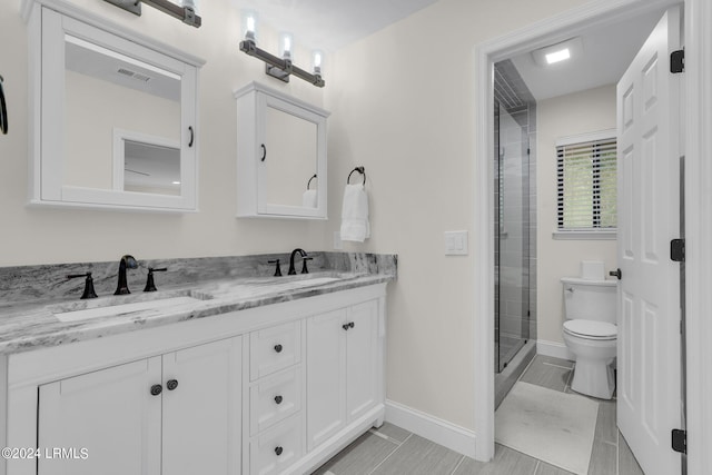 bathroom featuring vanity, toilet, and a shower with door