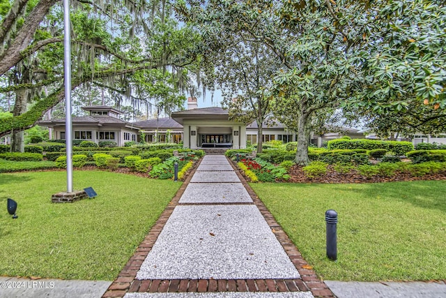 view of front of home with a water view and a front lawn