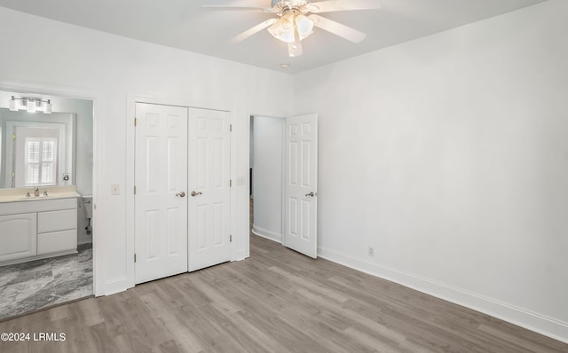 unfurnished bedroom with sink, ceiling fan, connected bathroom, light hardwood / wood-style floors, and a closet