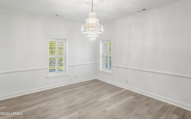 spare room with crown molding, a notable chandelier, and light hardwood / wood-style flooring