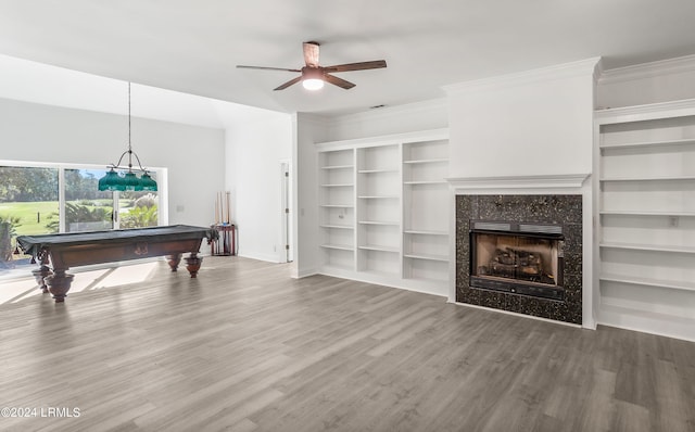 playroom featuring ceiling fan, wood-type flooring, ornamental molding, a tiled fireplace, and pool table