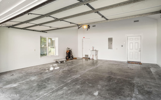 garage with a garage door opener, sink, and electric panel