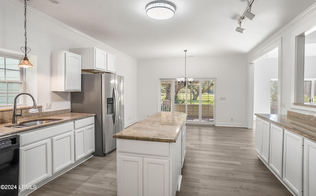 kitchen with sink, white cabinetry, hanging light fixtures, black dishwasher, and light stone counters