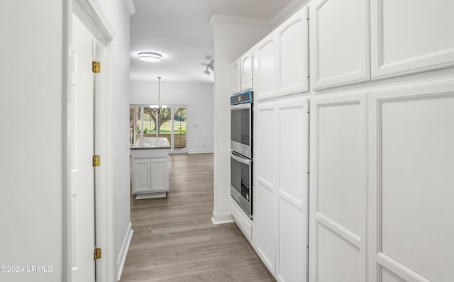 corridor featuring ornamental molding, a chandelier, and light hardwood / wood-style flooring